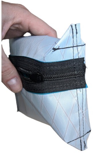 A close-up of a sewn corner of the zipper pouch, showing the stitching for the boxed bottom