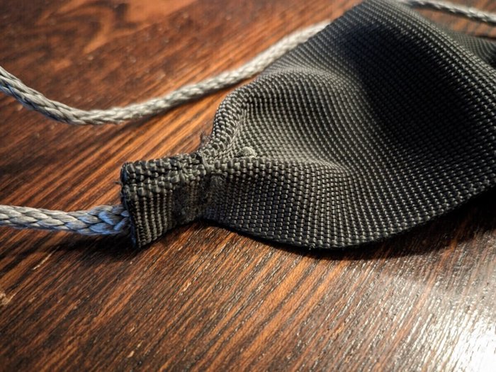 Webbing end pinched into a W shape, with the cord tucked into the W and bar tacked. Super simple project, so much fun